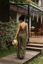Woman in a green outfit walking on a wooden path with a blurred background